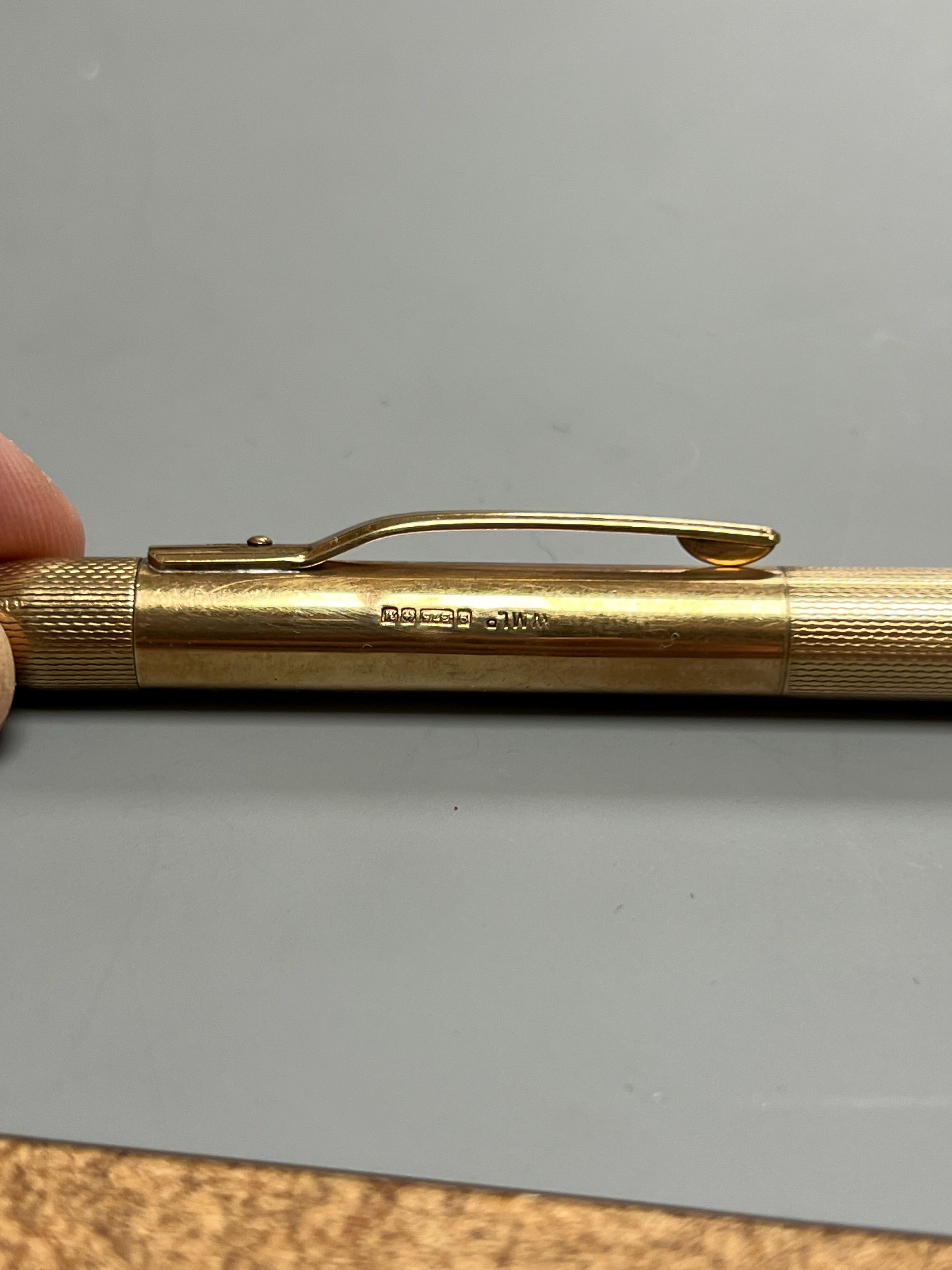 An engine turned 9ct gold propelling pencil